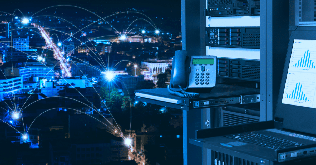A VoIP phone and server equipment with network connectivity graphics in a dark setting.