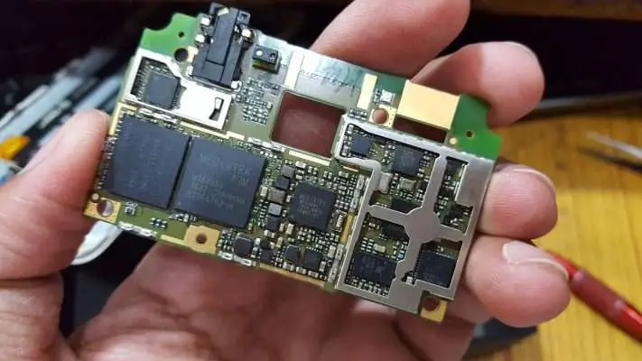 Hand holding a circuit board featuring MediaTek components and various electronic parts.